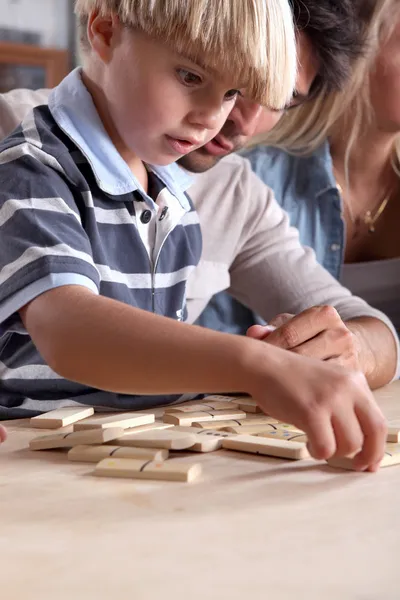 Jovem menino jogando dominó com seu pai — Fotografia de Stock