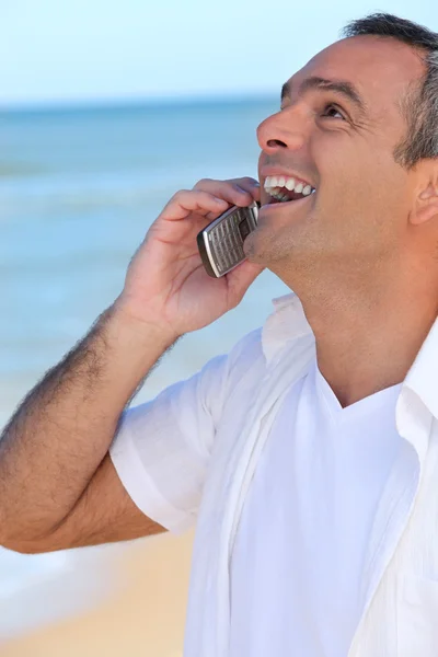 Зрелый мужчина смеется над своим телефоном — стоковое фото