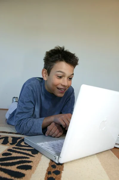 Jongen opleggen deken met laptop — Stockfoto