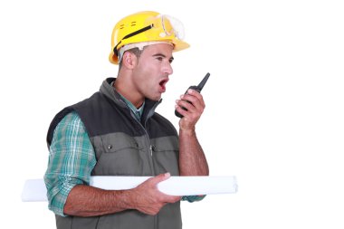 Tradesman yelling into a walkie-talkie clipart