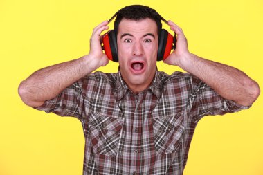 Craftsman wearing headphones can't stand the noise clipart