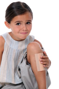 Young girl with an enormous plaster on her leg clipart
