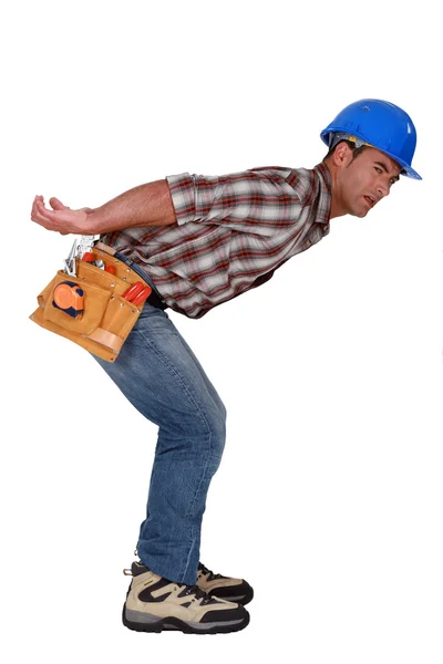 Trabalhador da construção civil carregando algo pesado — Fotografia de Stock