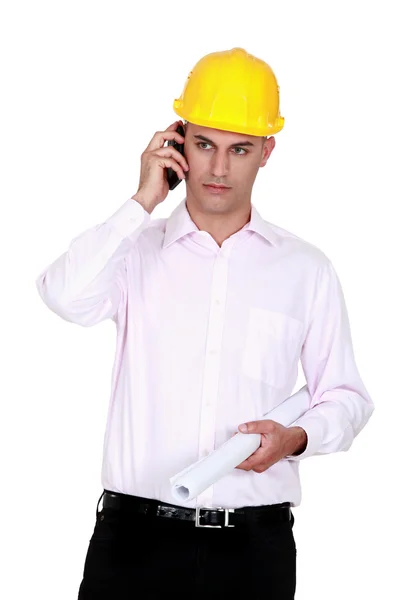 Uomo d'affari che indossa il casco e parla al telefono — Foto Stock