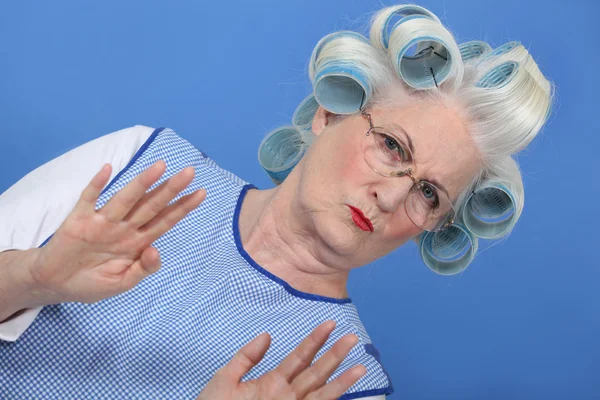 Бабушка с бигуди на синем фоне — стоковое фото