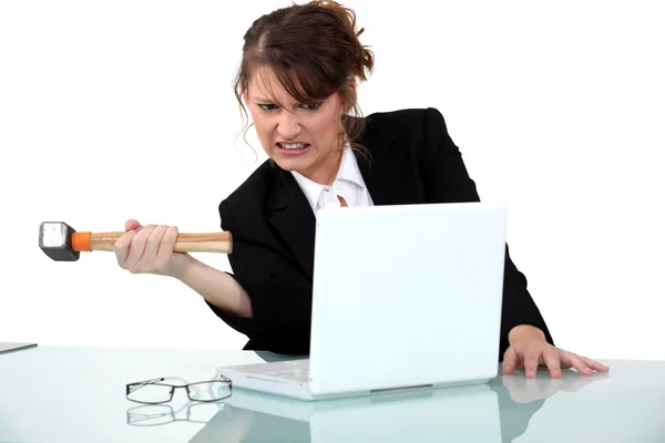 Woman threatening computer with hammer — Stock Photo, Image