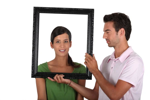 Attractive couple with frame — Stock Photo, Image