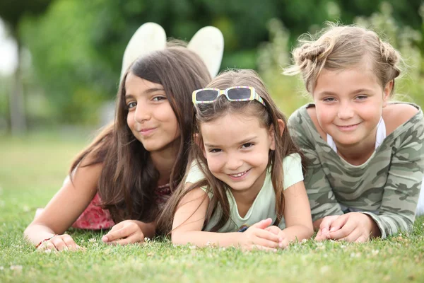 Drei junge Mädchen liegen im Gras — Stockfoto