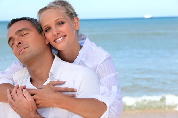 Älskande par på en strand — Stockfoto