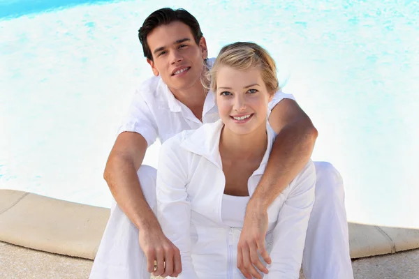Portret młoda para siedzi przy basenie — Zdjęcie stockowe