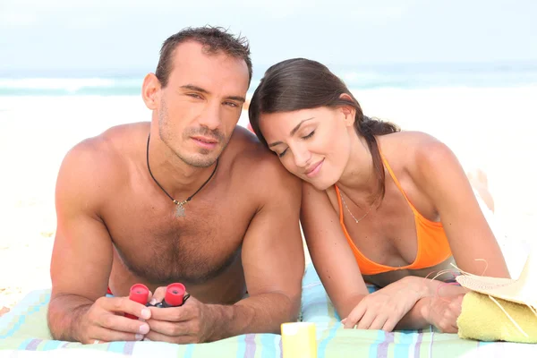 Jeune couple bronzant sur la plage — Photo