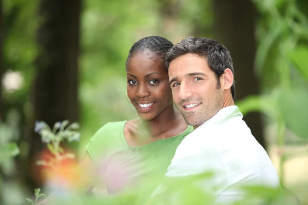 Interracial couple in a park. — Stock Photo, Image