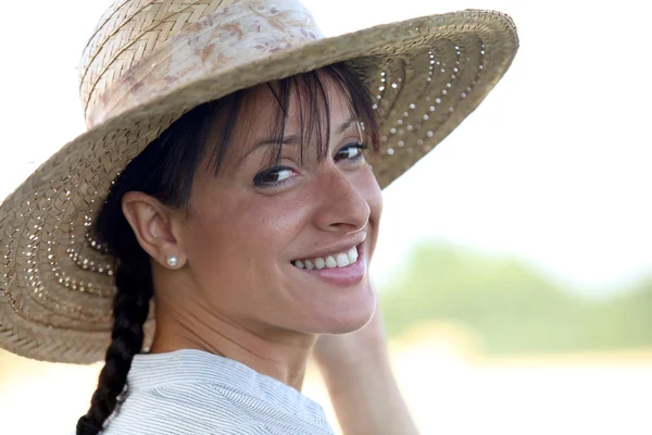 Attractive brunette wearing straw hat — Stock Photo, Image