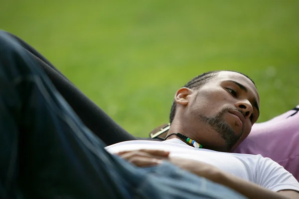 若い男が彼のガール フレンドと草で横になっています。 — ストック写真