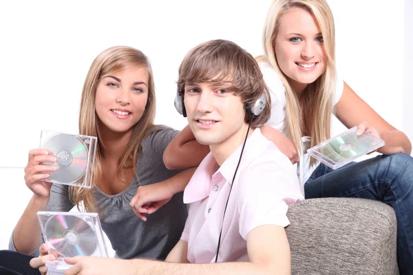 Teenagers listening to CDs on headphones — Stock Photo, Image