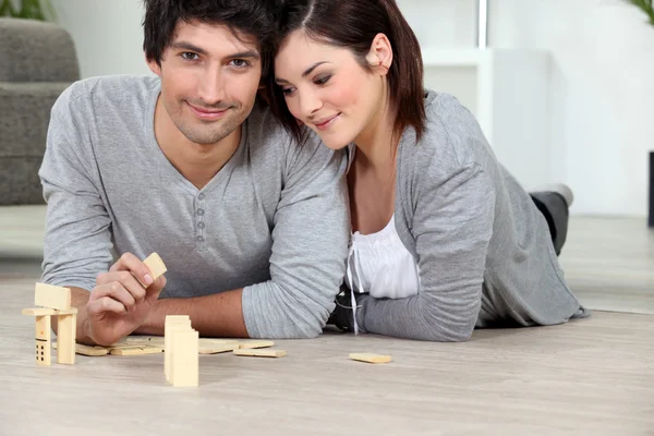 Junger Mann und junge Frau spielen Dominosteine — Stockfoto