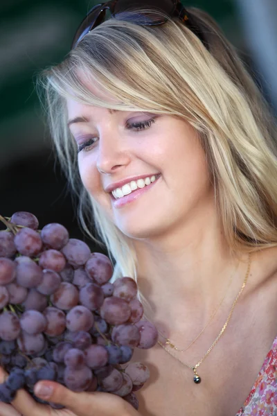 Blonde woman with bunch of grapes — Stock Photo, Image