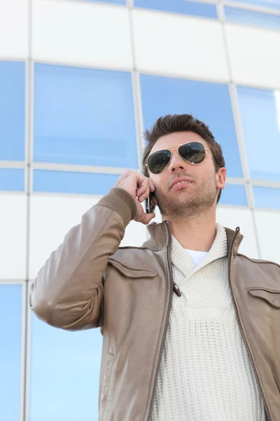 Urban man in aviators with a mobile phone — Stock Photo, Image