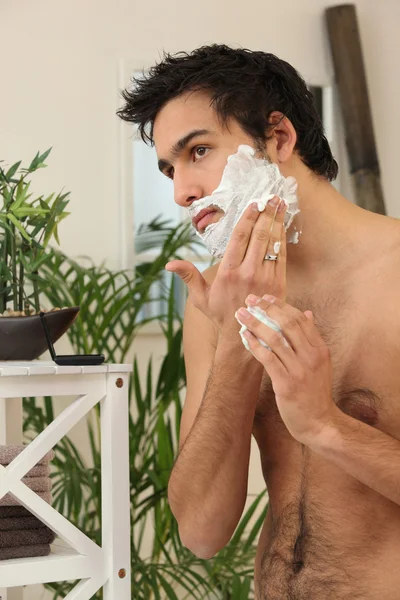 Jovem aplicando creme de barbear — Fotografia de Stock