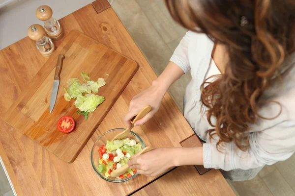 Dívka připravuje salát na desce — Stock fotografie