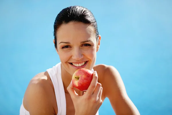 Cheerful woman eating an apple — Stock Photo, Image