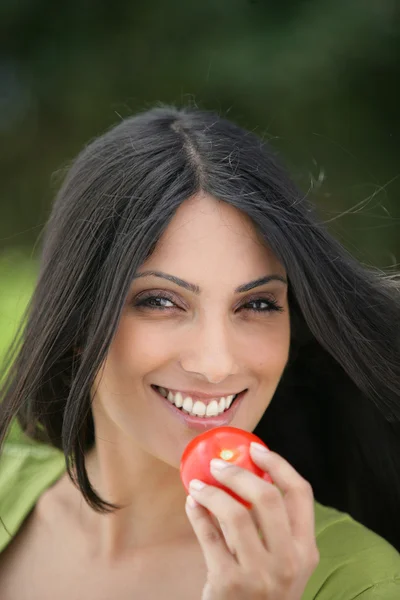Femme indienne mangeant une tomate — Photo