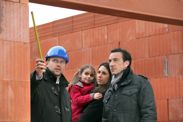 Arquiteto no local com uma família jovem — Fotografia de Stock