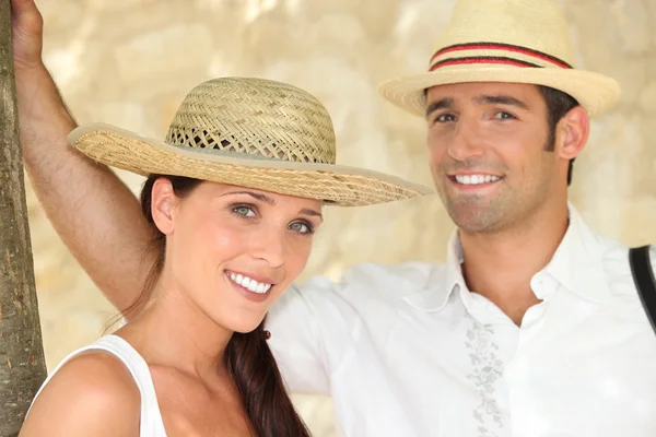 Koppel alle glimlacht dragen van stro hoed — Stockfoto