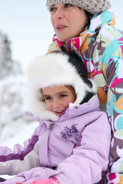 Moeder en dochter spelen in de sneeuw — Stockfoto
