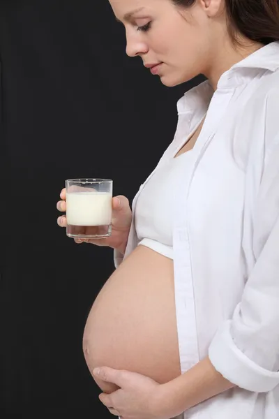Mujer embarazada bebiendo un vaso de leche — Foto de Stock