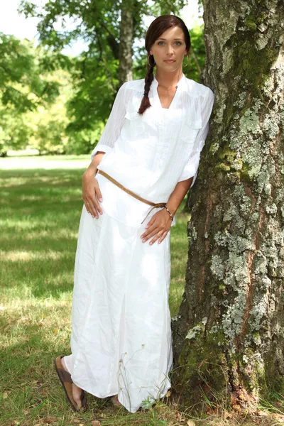 Woman leaning against tree — Stock Photo, Image