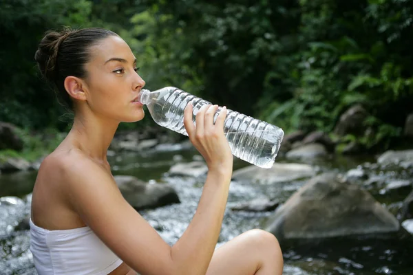 Женщина пьет пресную родниковую воду — стоковое фото