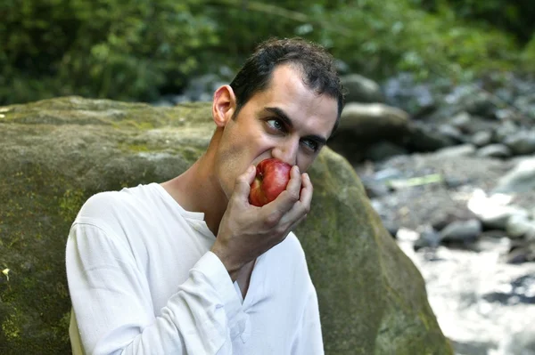 Человек на горной прогулке ест яблоко — стоковое фото