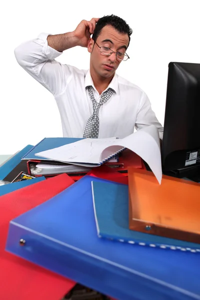 Trabalhador de escritório rodeado de papelada — Fotografia de Stock