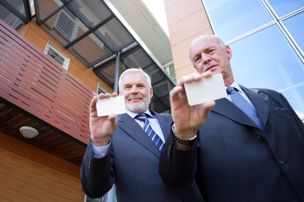 Deux hommes d'affaires de haut niveau affichant leurs cartes de visite — Photo