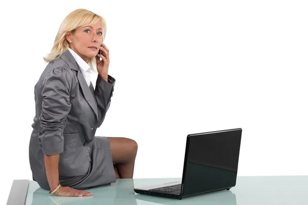 彼女の机の上に座ってシニア女性実業家 — ストック写真