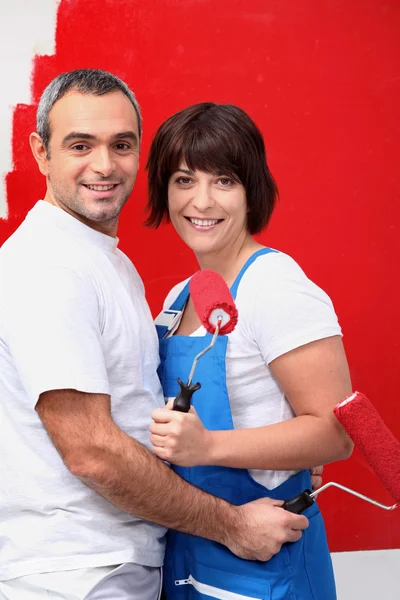 Couple painting a room bright red Stock Image