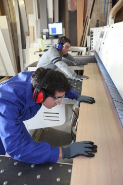 Laborers working on industrial machines clipart