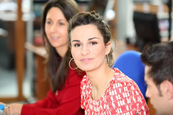 Brunette in office with colleagues — Stock Photo, Image