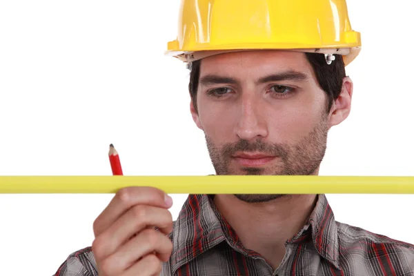 Bir kalem ve ölçü birimi ile bir kask içinde adam — Stok fotoğraf