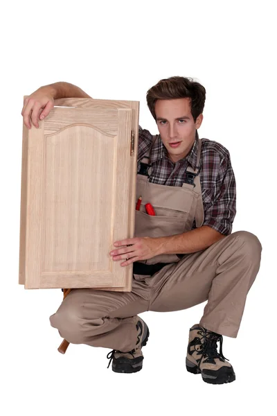 Trabajador de madera sosteniendo un marco de ventana — Foto de Stock