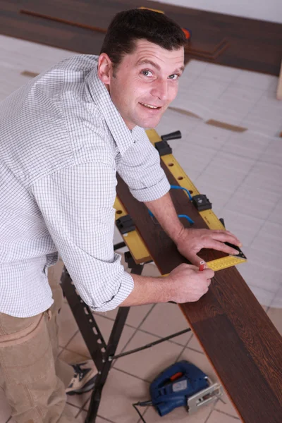 Man tot vaststelling van een houten vloer — Stockfoto