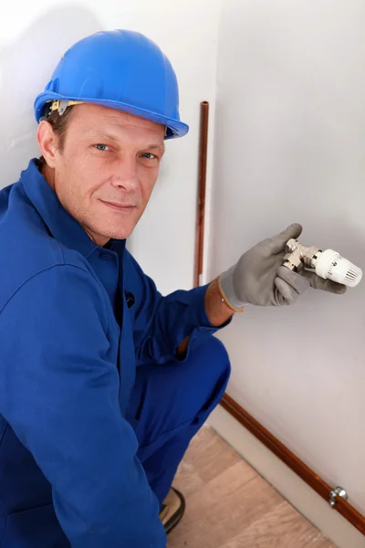 Workman holding a radiator temperature dial — Stock Photo, Image