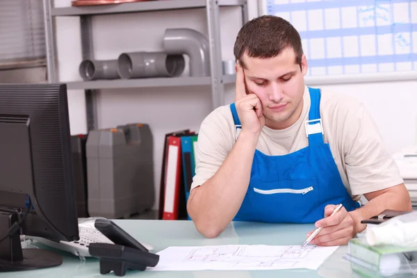 Man working in a plumbers office — Stock Photo, Image