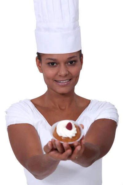 Young female baker holding pastry — Stock Photo, Image