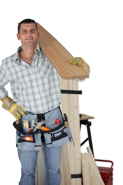 Tischler trägt eine Holzplanke — Stockfoto