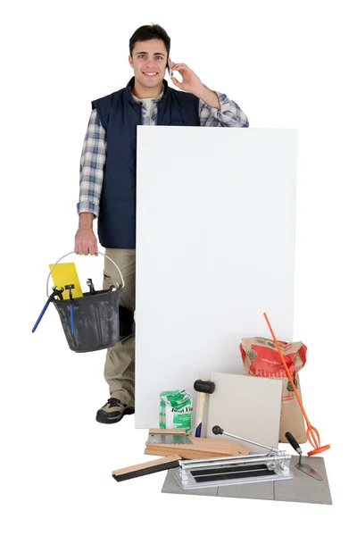 Tiler with a phone and a blank board — Stock Photo, Image