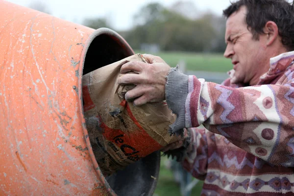 Mann legt Zement in einen Mixer — Stockfoto