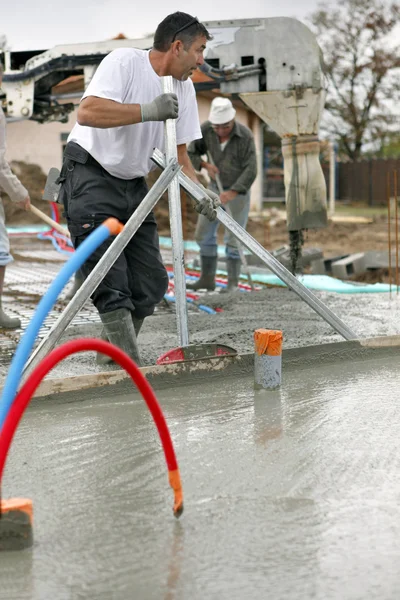 Lavoratori versando una fondazione di cemento — Foto Stock