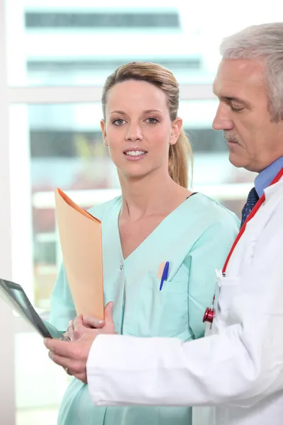 Krankenschwester diskutiert mit Arzt über eine Röntgenaufnahme — Stockfoto